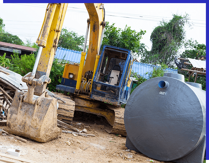 A large metal tank sitting next to a yellow and blue truck.