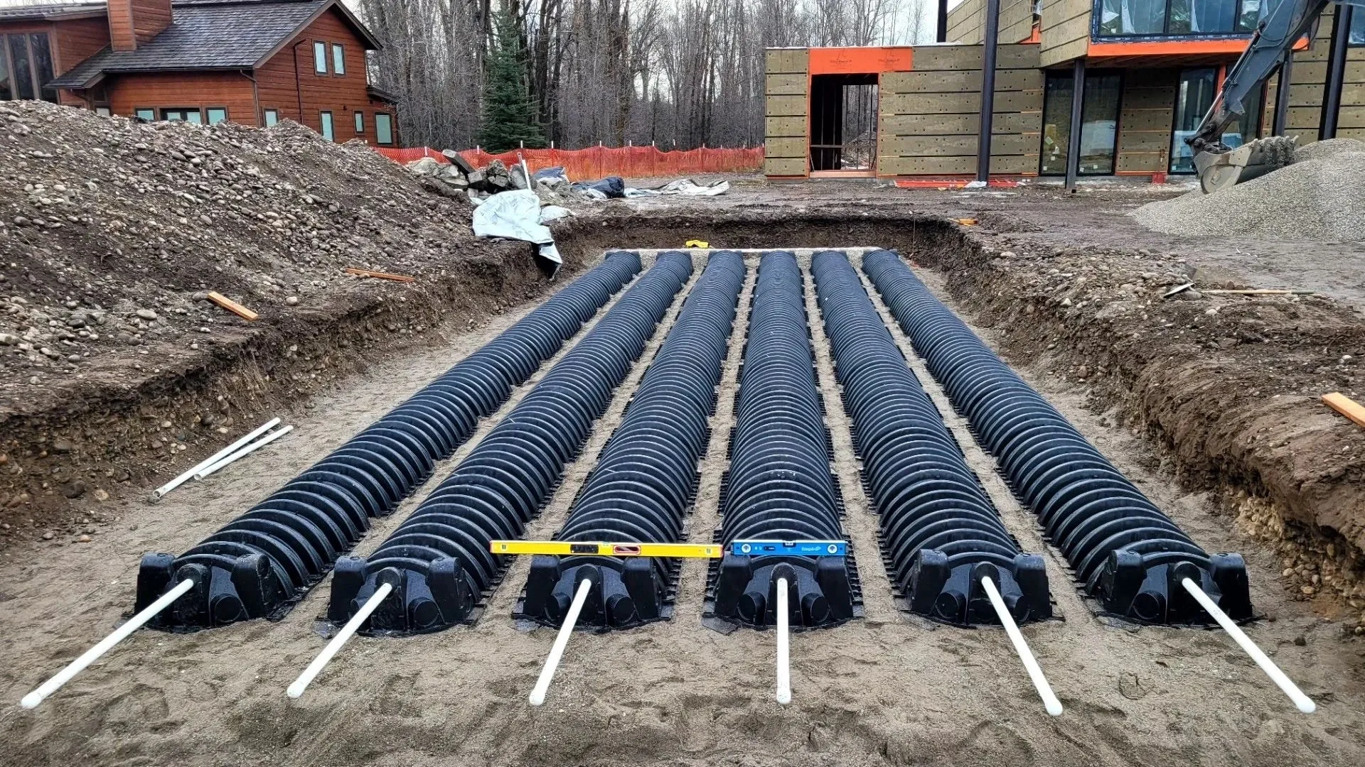 A group of pipes in the ground with construction tape around them.