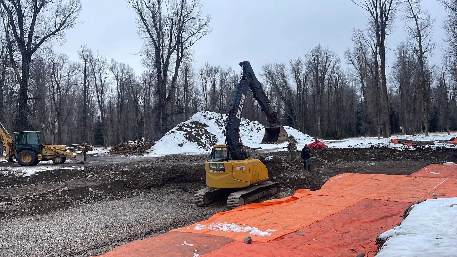 A yellow and black excavator on the side of road.