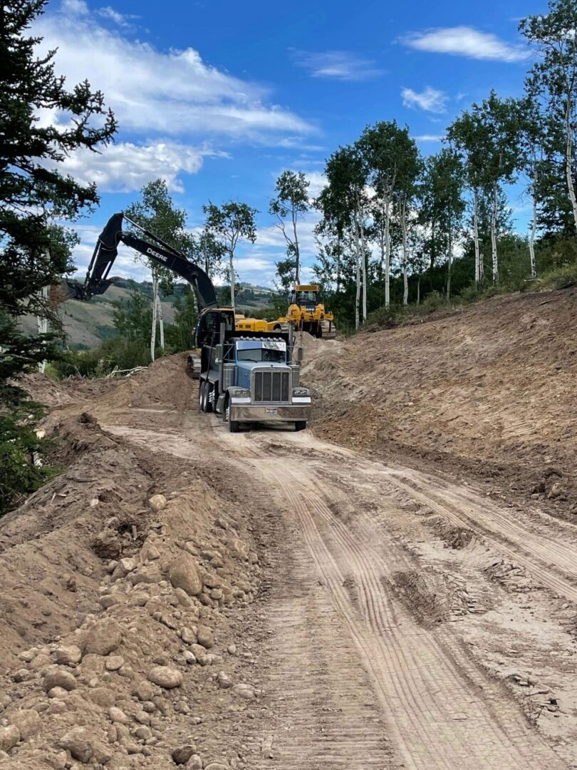 A truck is driving down the dirt road.