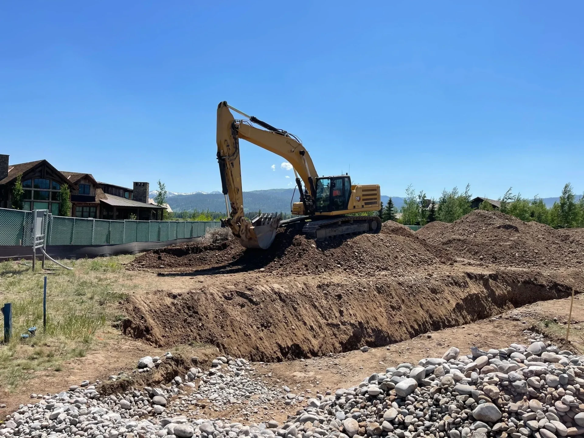 A yellow and black excavator is on the dirt