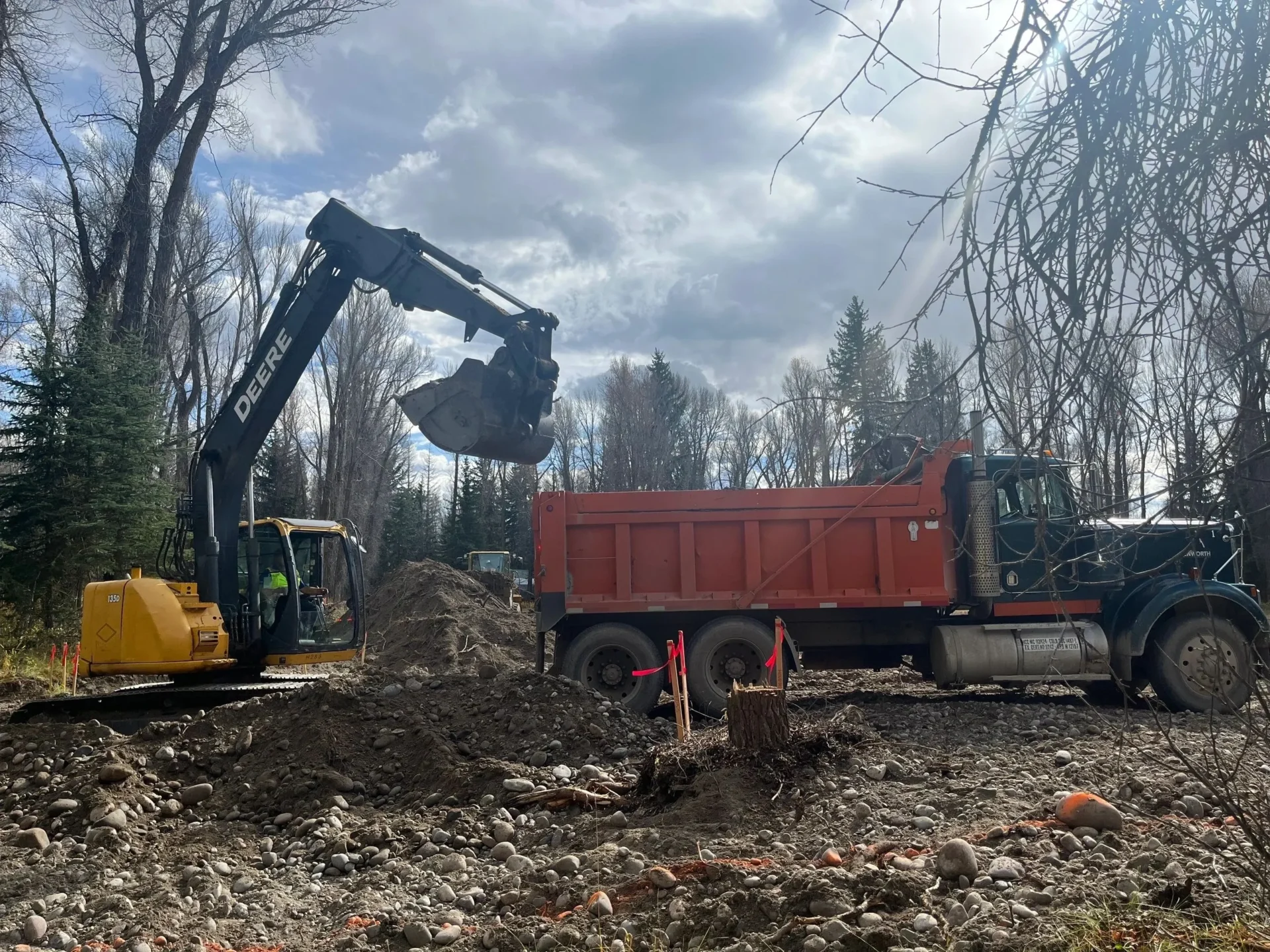 A large truck is parked in the dirt.