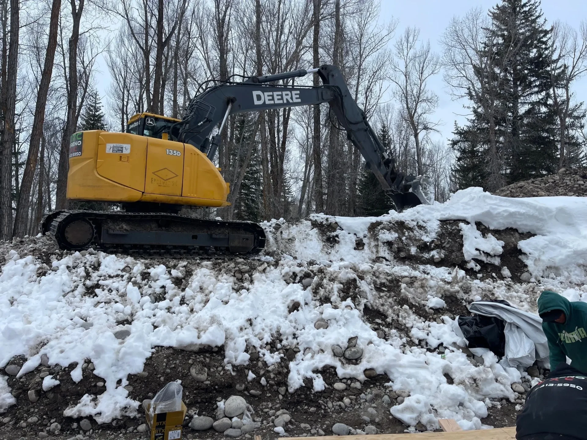 A yellow and black tractor is in the snow