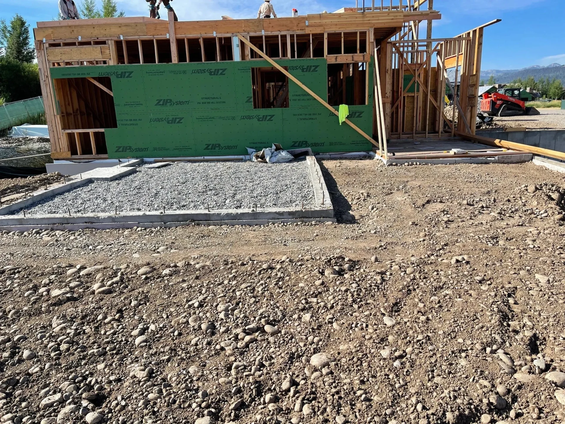 A green building sitting on top of gravel.