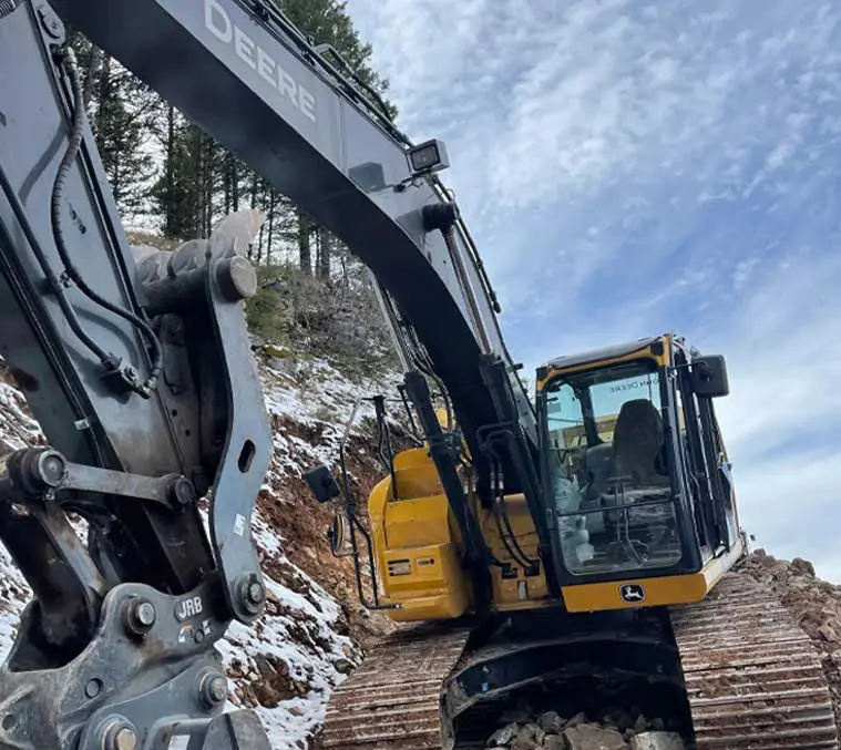 A yellow and black excavator is on the tracks