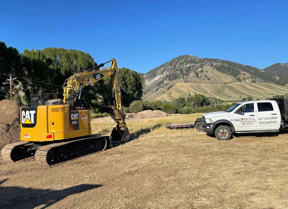 A yellow and black machine on the ground near some trees